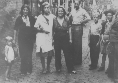 879130 Portret van een groepje feestvierders op een bevrijdingsfeest in de Achterstraat in Wijk C te Utrecht, met links ...